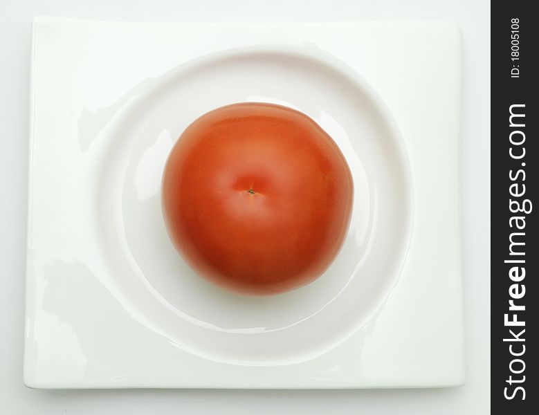 Tomato On White Plate.