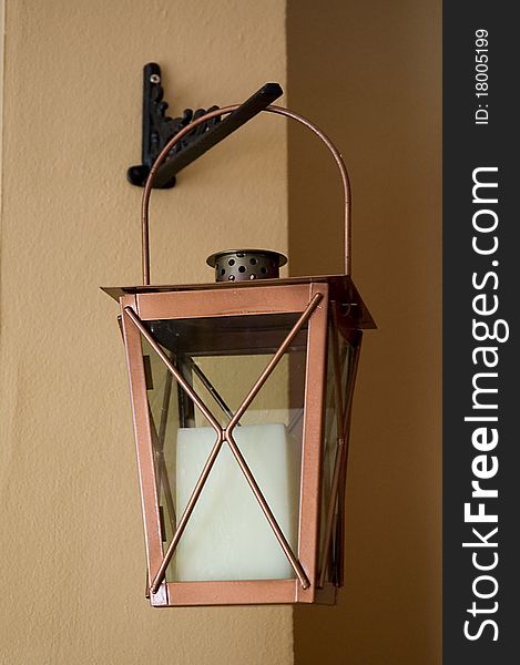 An old candle lantern hanging on a wall