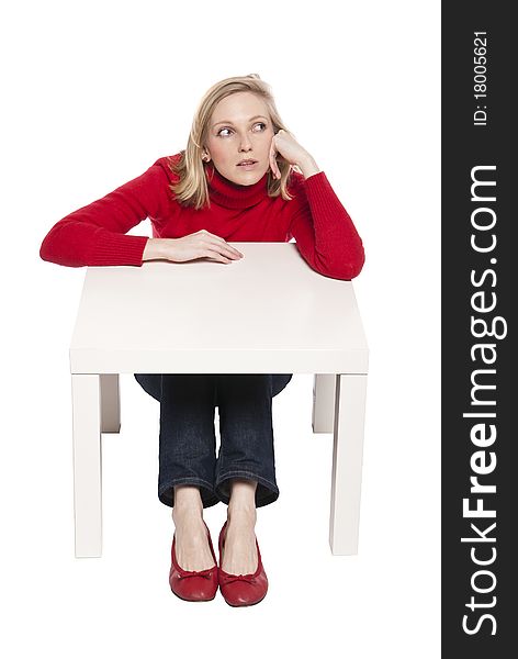 Young woman sitting at funny small desk