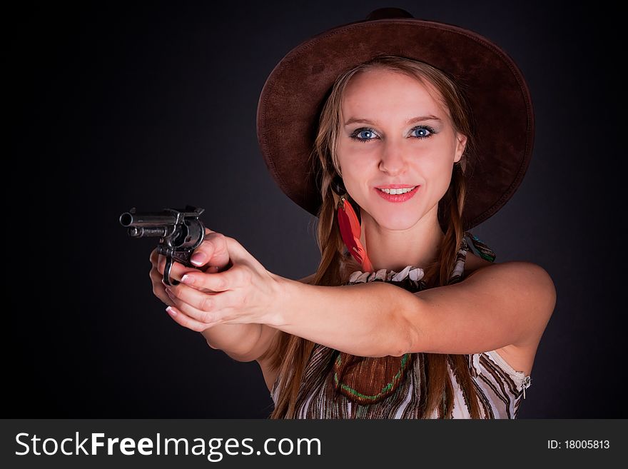 The American Indian girl in a cowboy's hat holds a pistol