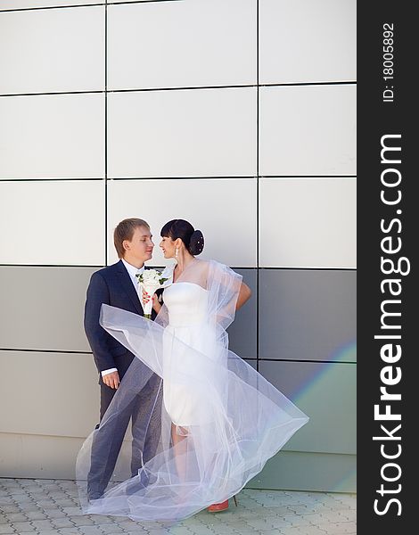 Bride and groom by the wall. Bride and groom by the wall