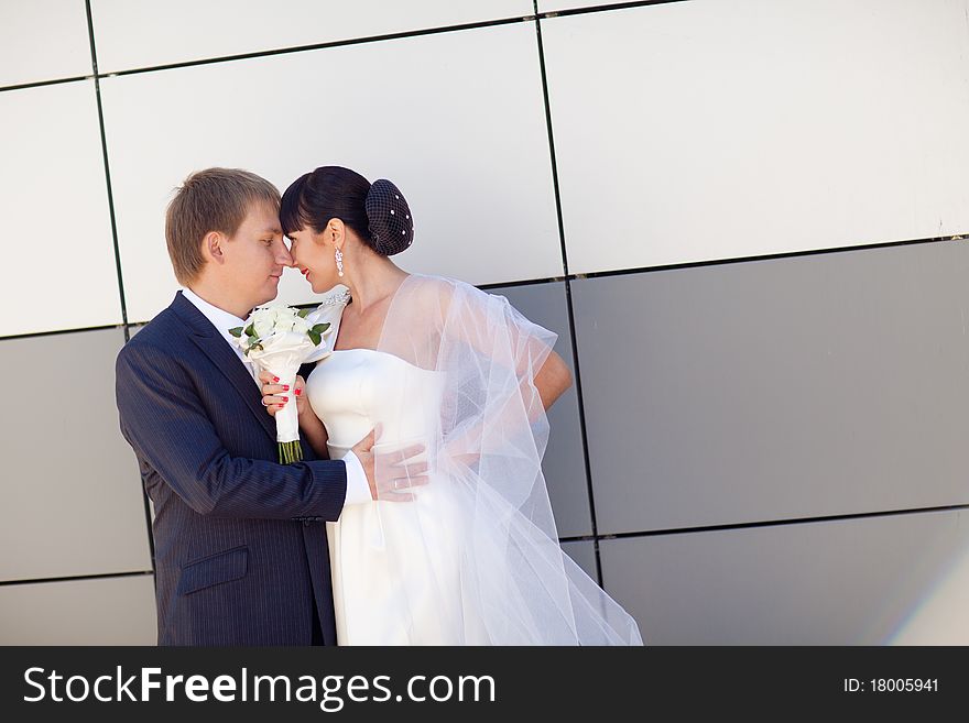 Bride and groom by the wall