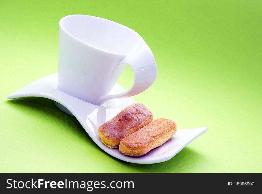 Milk cup and crackers on green background