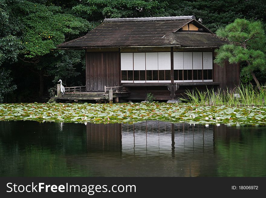 An old japanese house reflected in the lake with trees around. An old japanese house reflected in the lake with trees around