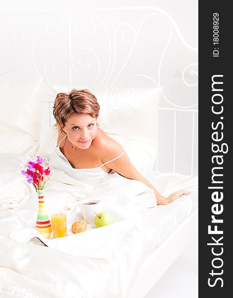 Beatiful woman having breakfast in white bed. Beatiful woman having breakfast in white bed