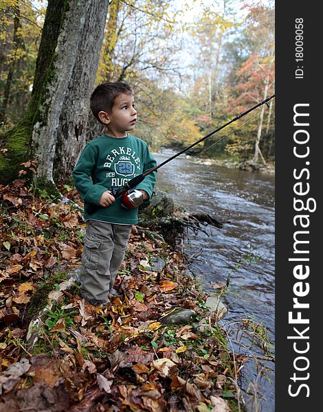 A boy fishing at a stream