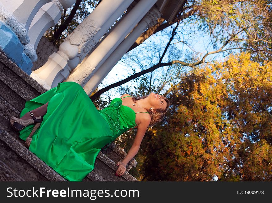 Beauty woman in green clothes sit on stair