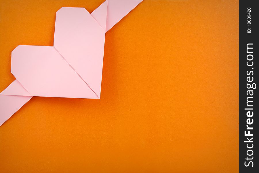 Paper heart over orange background