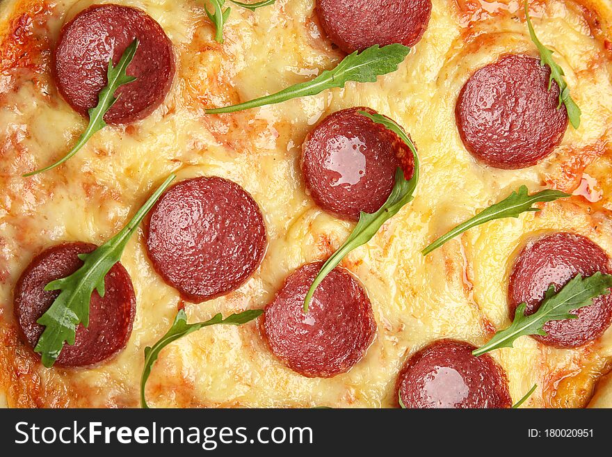 Tasty pepperoni pizza with arugula as background, top view