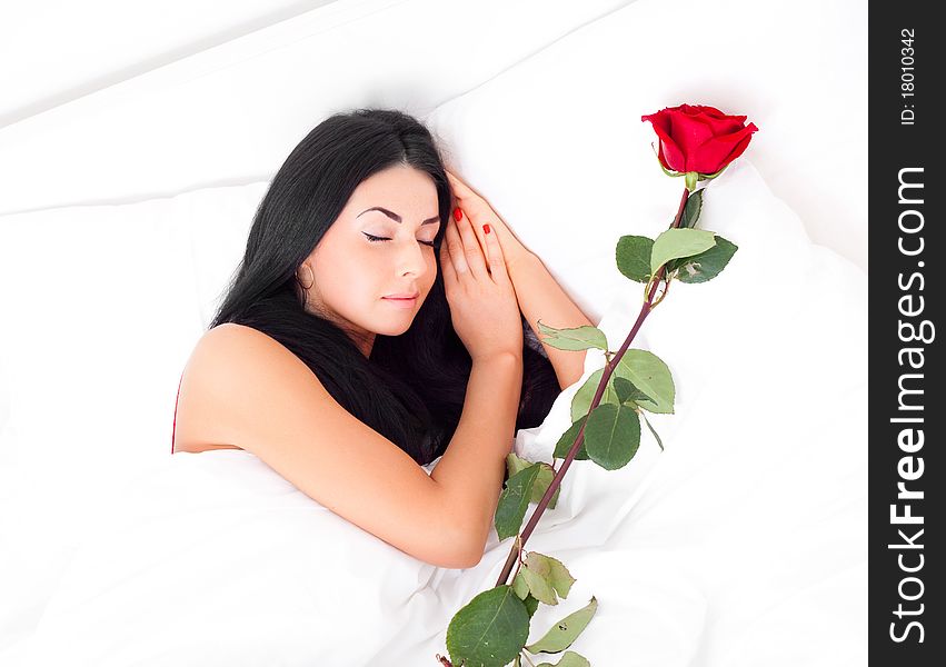 Beautiful brunette woman sleeping at home with a rose near her. Beautiful brunette woman sleeping at home with a rose near her