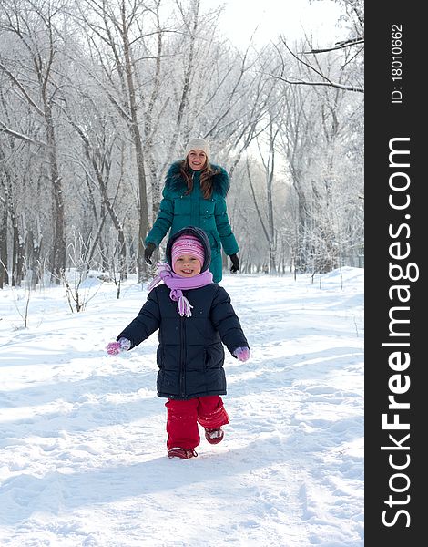 Mother and  kid having fun outdoors on  winter day