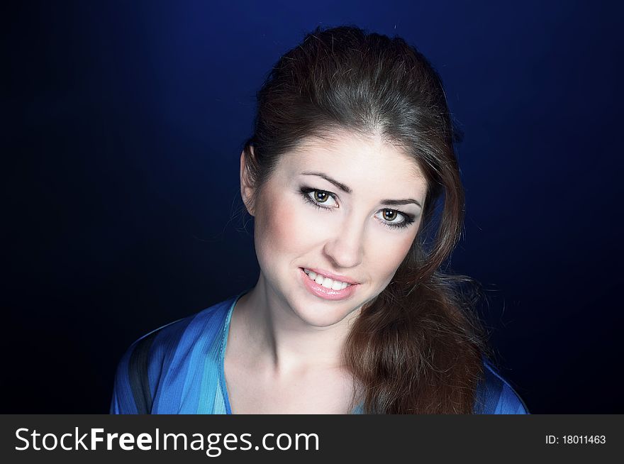 Beautiful young smiling girl on the blue background