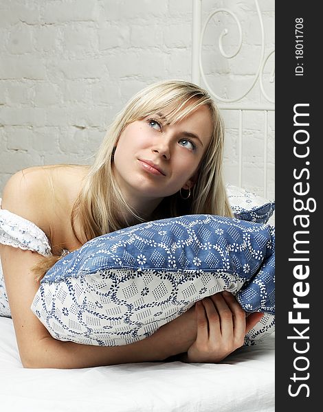 Shot of a young attractive blond woman lying in bed. Very brightly lit. Shot of a young attractive blond woman lying in bed. Very brightly lit