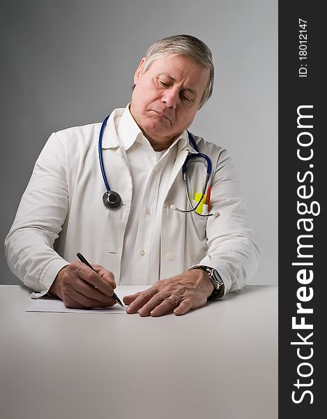 Senior doctor writing a prescription