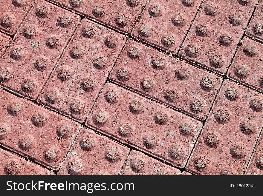 A pattern of brick red building blocks with eight circles each. A pattern of brick red building blocks with eight circles each.