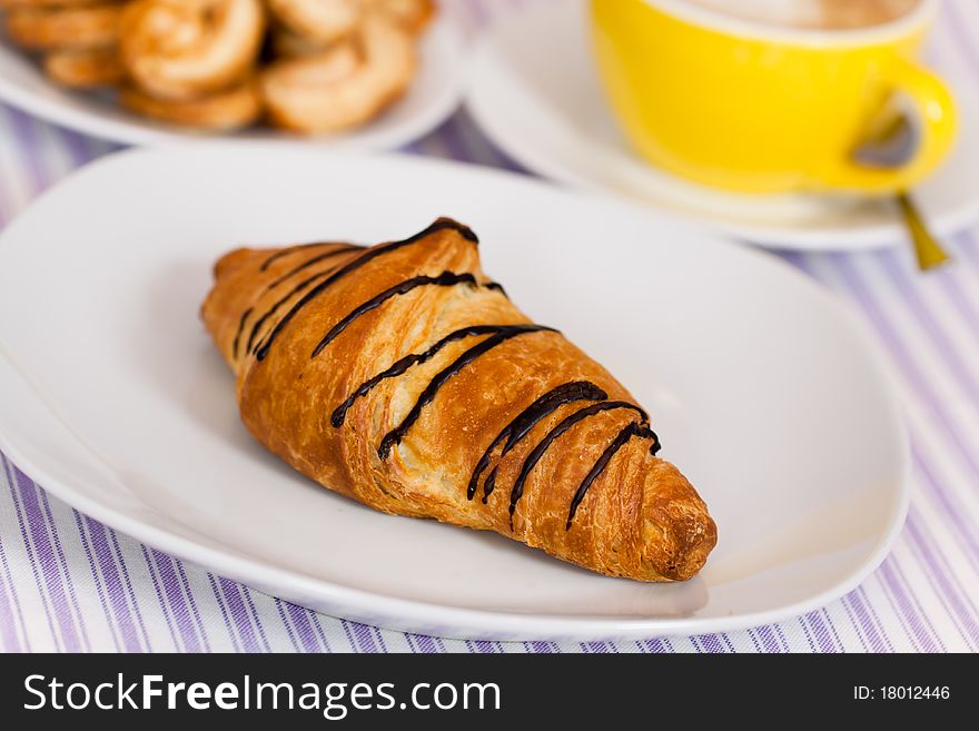 Cappuccino and chocolate croissant isolated on whi