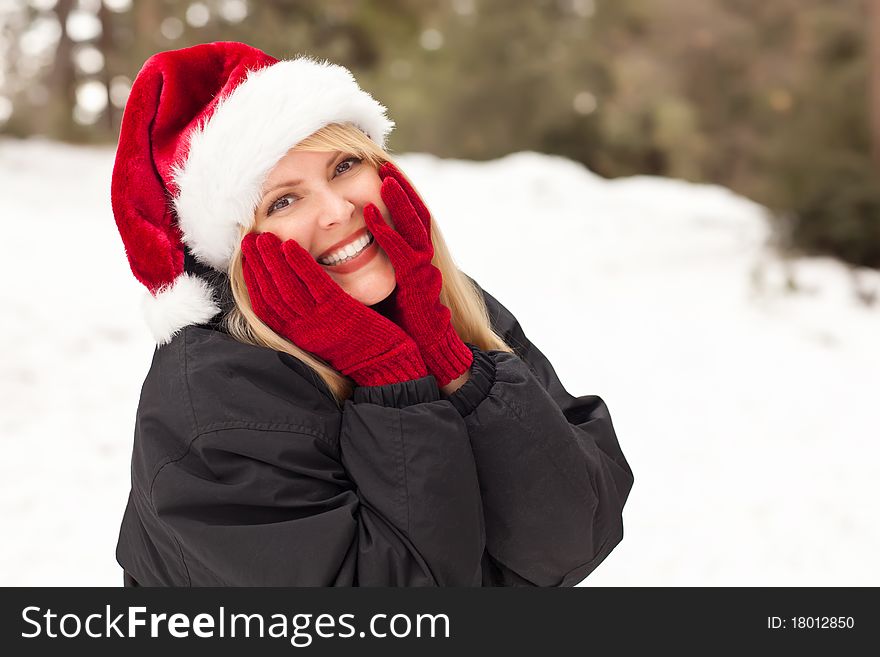 Attractive Santa Hat Wearing Blond Woman Having Fun in The Snow on a Winter Day. Attractive Santa Hat Wearing Blond Woman Having Fun in The Snow on a Winter Day.
