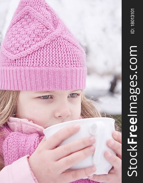 Girl drinking tea outside in the snow