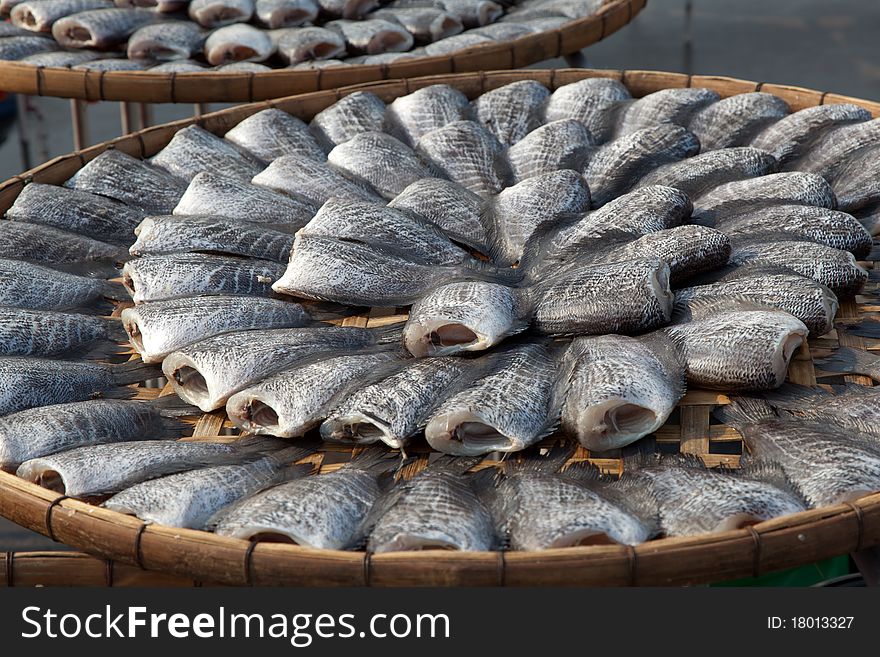 Processed and carved Gourami fish were arranged in flat bamboo basket among a hard sunny day to make Thai traditional preserved  food. Processed and carved Gourami fish were arranged in flat bamboo basket among a hard sunny day to make Thai traditional preserved  food.