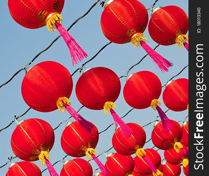 Red Chinese new year lantern and pink bob rows in front of blue sky. Red Chinese new year lantern and pink bob rows in front of blue sky.