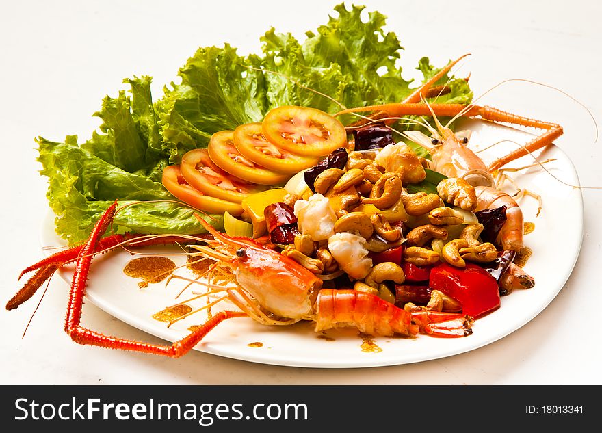 A dish of asian food included with mixed vegetable and shrimp.