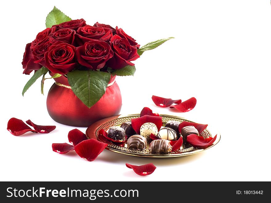 Beautiful roses in pot with gold plate of chocolates. Beautiful roses in pot with gold plate of chocolates