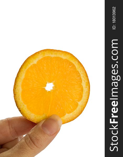 Fingers holding an orange slice up against a flat white background.