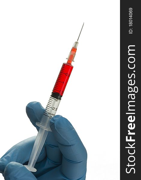 Isolated syringe with blue gloved hand holding it. Isolated syringe with blue gloved hand holding it