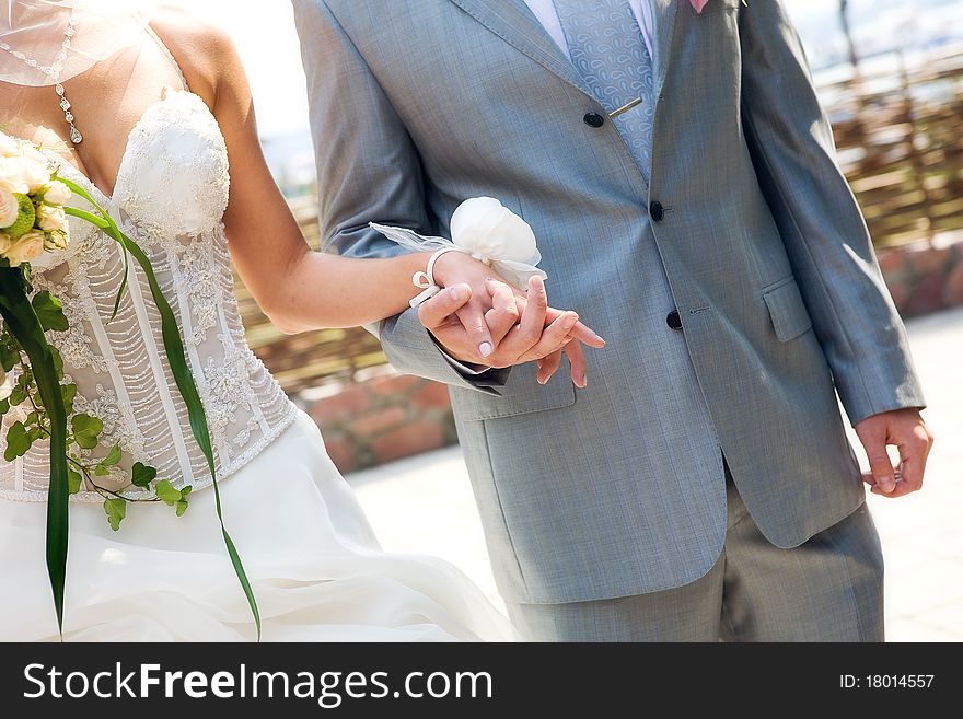 The bride and groom holding hands. The bride and groom holding hands