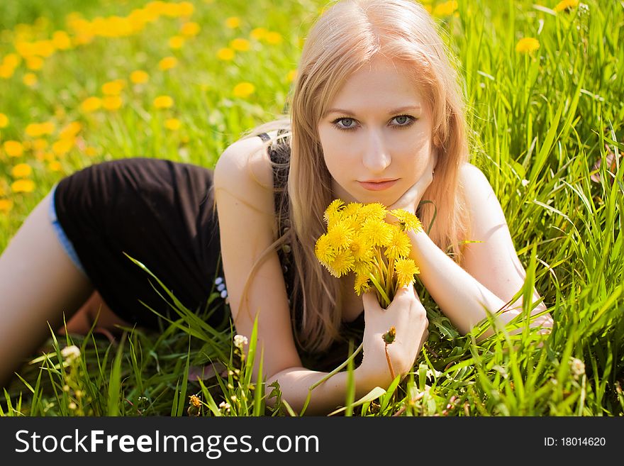 Beautiful woman with dandelions in hands