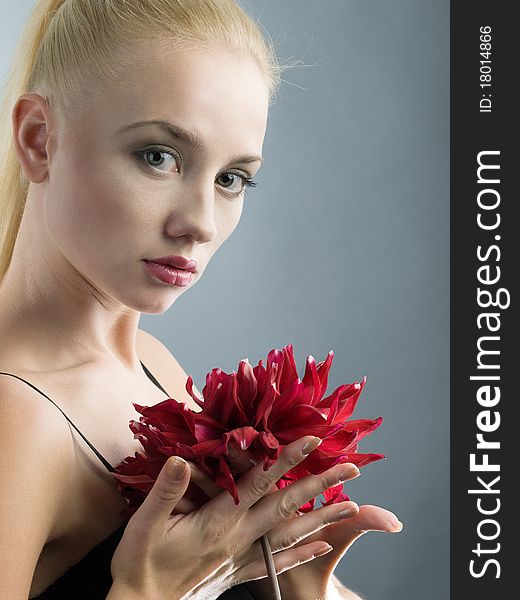 Elegant blonde girl in black dress and red flower at hand. Elegant blonde girl in black dress and red flower at hand