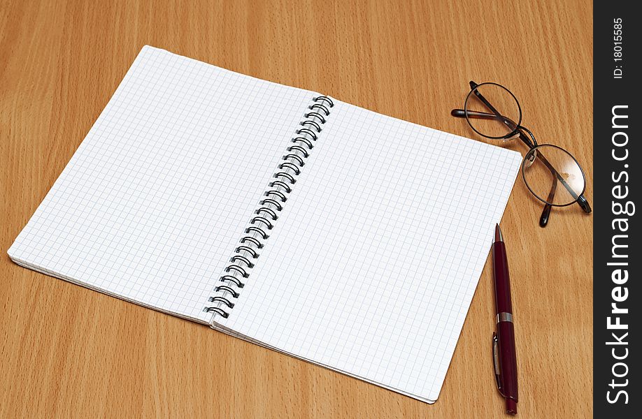 Notebook, glasses and pen on the table. Notebook, glasses and pen on the table.