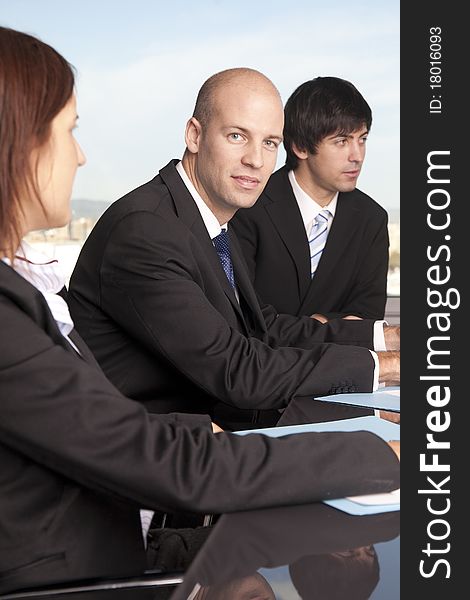 Businessteam of three persons relaxed at the table in front of city panorama. Businessteam of three persons relaxed at the table in front of city panorama