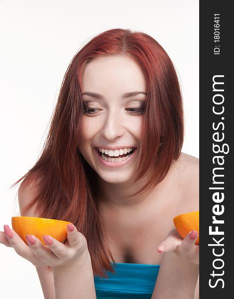 A beautiful redhead woman holding a half of orange isolated on white. A beautiful redhead woman holding a half of orange isolated on white