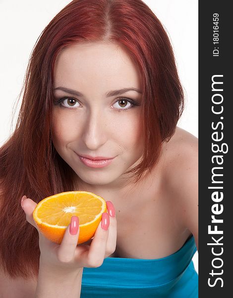 A beautiful redhead woman holding a half of orange isolated on white. A beautiful redhead woman holding a half of orange isolated on white