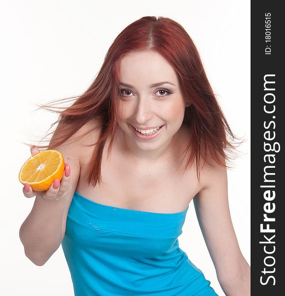 A beautiful redhead woman holding a half of orange isolated on white. A beautiful redhead woman holding a half of orange isolated on white