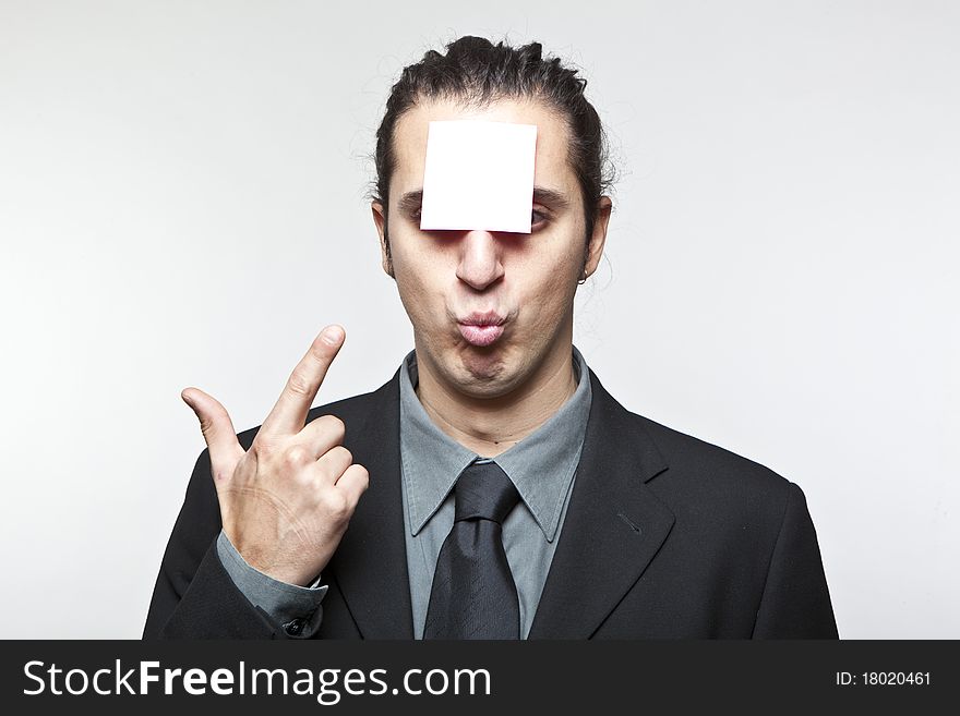 Young man with blank note on the face on white