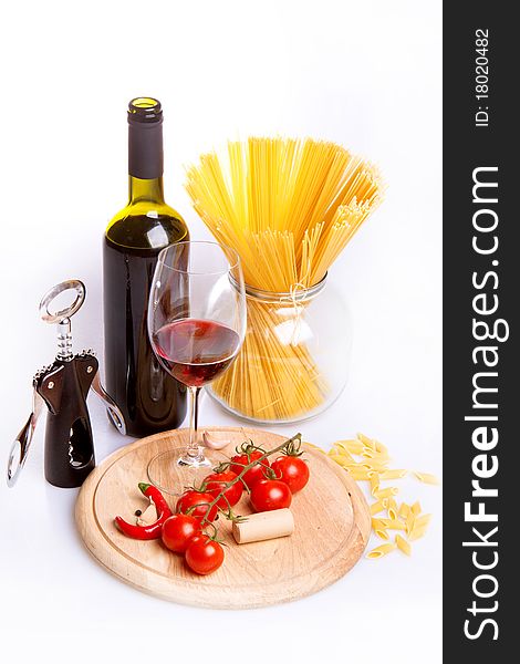 Glass of red wine near italian spaghetti and vegetables for pasta. Glass of red wine near italian spaghetti and vegetables for pasta