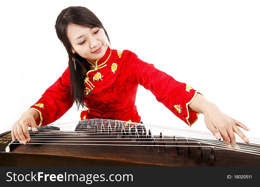 Chinese zither performer in traditional dress playing zither on white. Chinese characters on Chinese zither are Chinese poems. Chinese zither performer in traditional dress playing zither on white. Chinese characters on Chinese zither are Chinese poems.