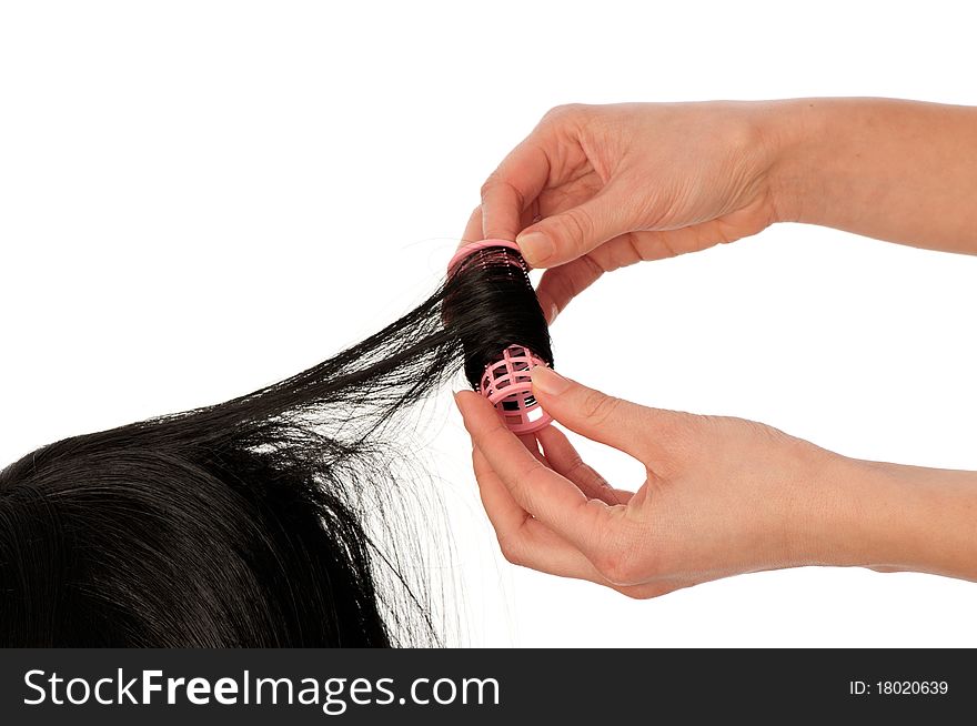 Hairdresser makes curls on the woman's black hair