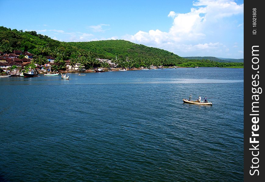 A scene of a beautiful lake with a small boat cruising toward distant mountain. A scene of a beautiful lake with a small boat cruising toward distant mountain.