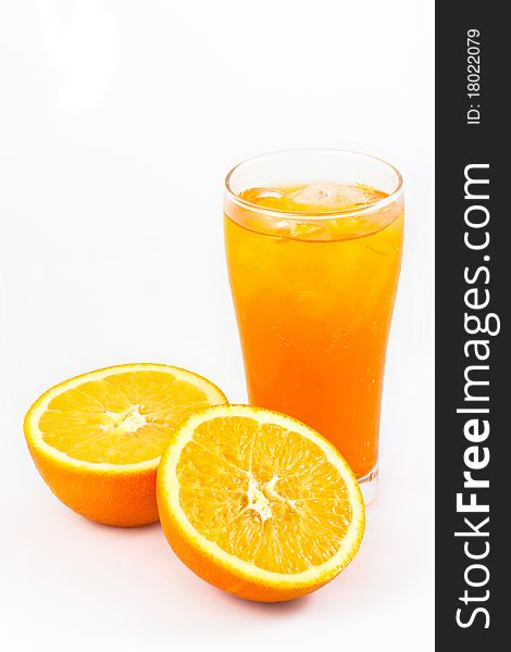 Orange juice in glass with half cut fresh oranges