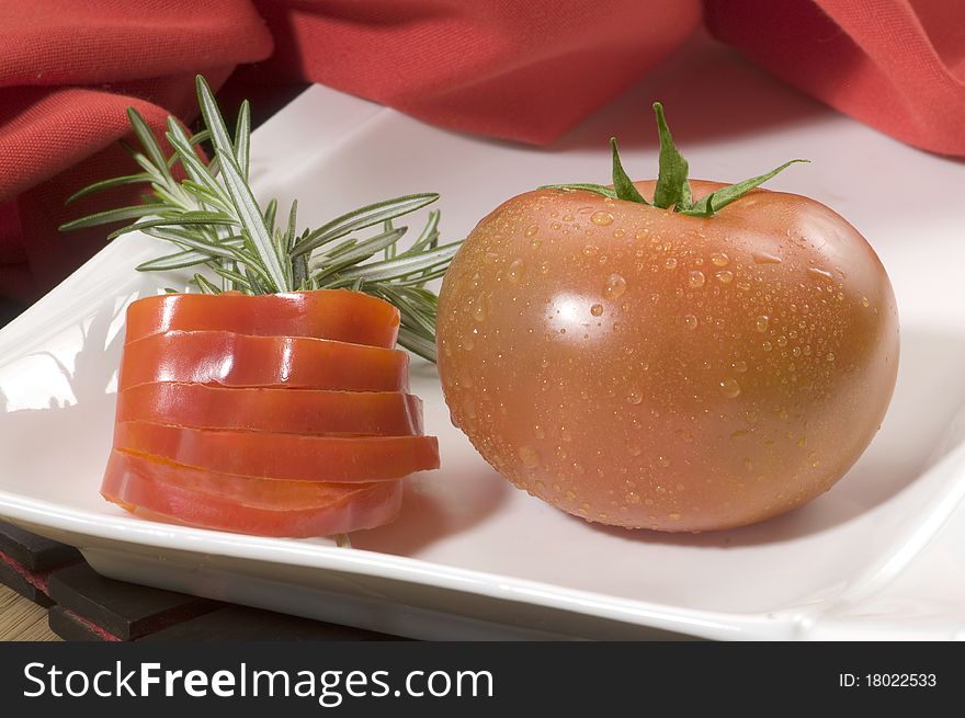 Tomato white plate decorated with tomato slices. Tomato white plate decorated with tomato slices