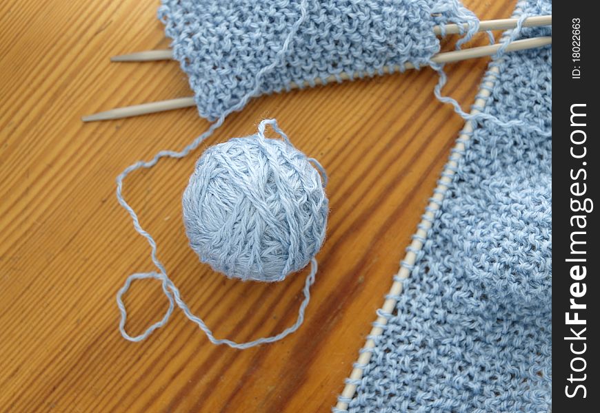 Knitting wool and needles on a wooden table