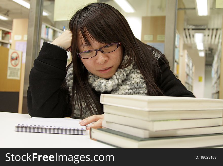 An Asian girl who is reading and studying