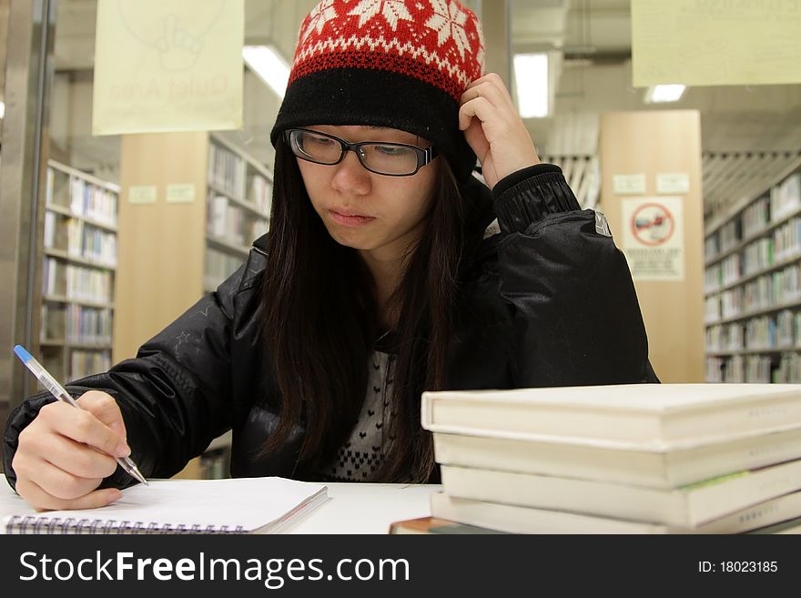 An Asian girl who is reading and studying