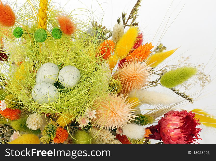 Three cute little quail eggs on colorful dry flowers - Easter decoration background