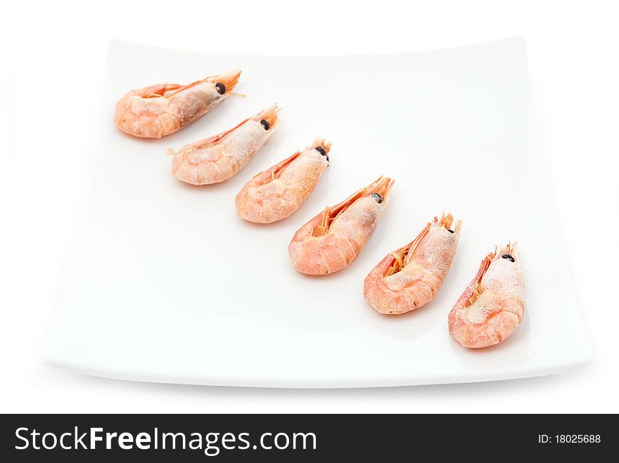 Row from fried prawns on plate. Isolated on white. Row from fried prawns on plate. Isolated on white