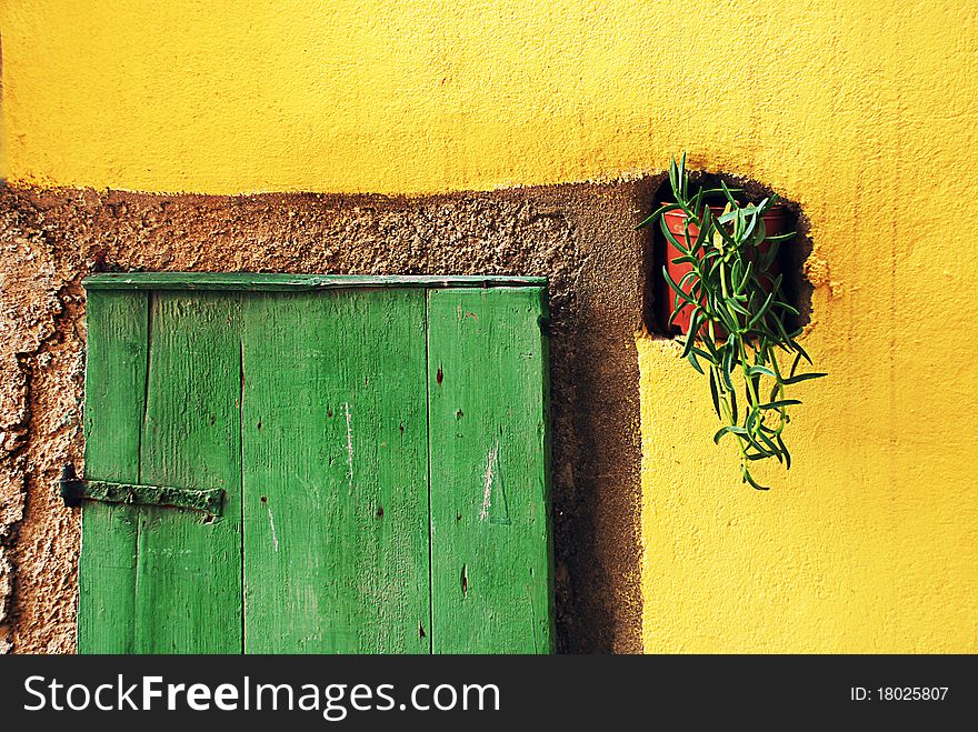Image of adriatic island green door on yellow wall