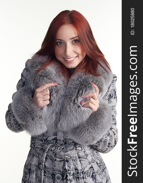 A portrait of a redhead woman in a grey coat with fur. A portrait of a redhead woman in a grey coat with fur